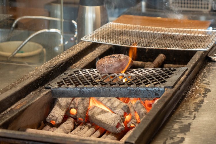備長炭が赤々と燃える上で、ハンバーグにおいしそうな焼き目が付く
