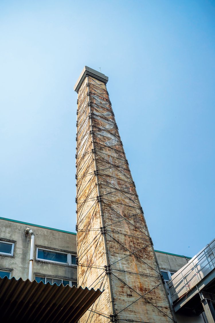 酒蔵の象徴、大正12年（1923）に建てられ、呉空襲の被害を唯一逃れた約26mの煙突がいまも残る。 　