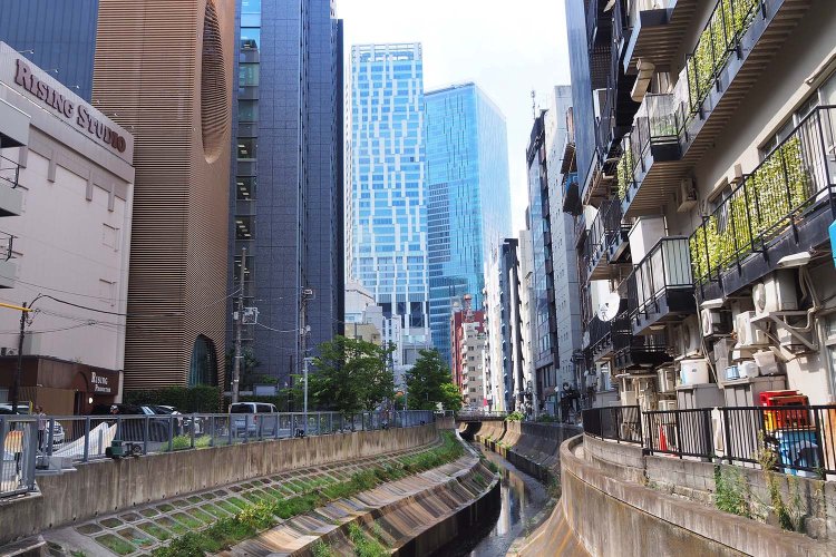 渋谷川がつくる空間の向こうに顔をのぞかせる、渋谷駅前のビルたち。
