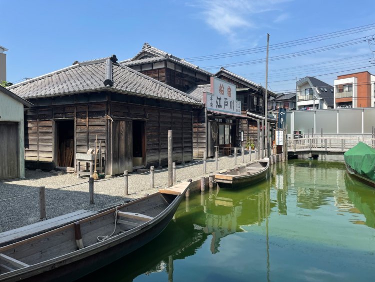 川に係留された舟と、船宿「江戸川」。船宿手前には漁師の家。