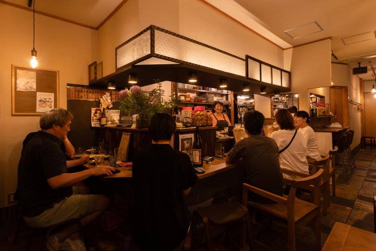 益子焼の器や柿渋ののれんにも女将の美意識が。奥のカウンターは初代から使いこんだ店の宝。