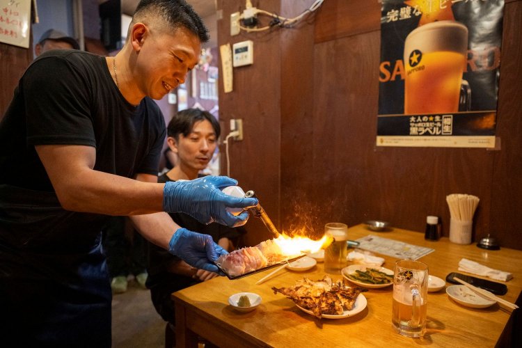 刺し身の2種盛りを炙りで頼むお客も。「一番大切なのはお客さんへの気配り！」と大将（左）。