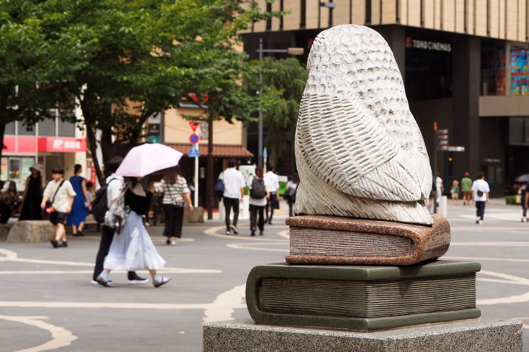 中池袋公園には、行き交う人々を本の上から眺めるふくろうがいた。