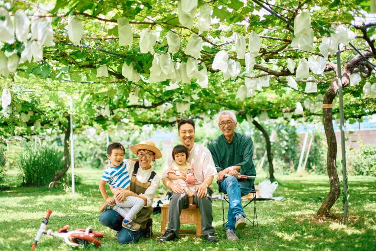 右から井上洋司さん、有本琢磨さん・さなさん夫妻と子供たち。ブドウ畑は周囲より気温が低く、心地よい風が抜ける。