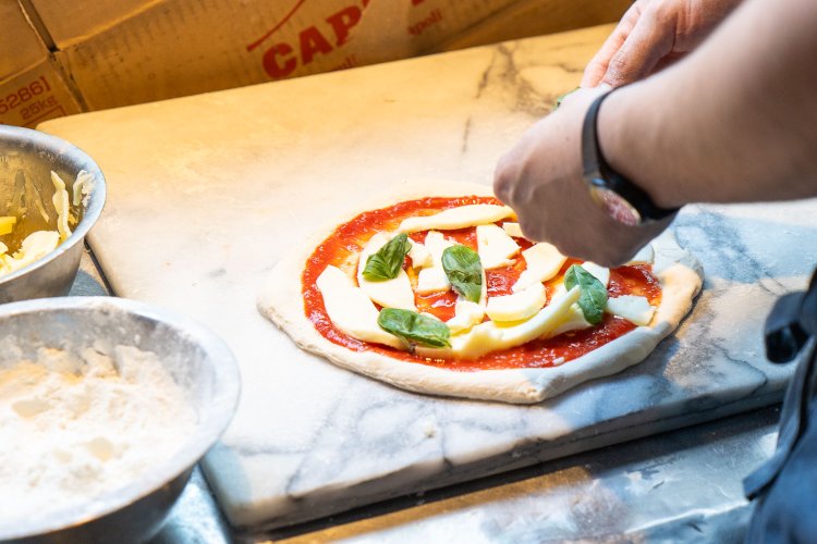 マルゲリータはバジルを散らしたあと、さらに粉チーズをかける。