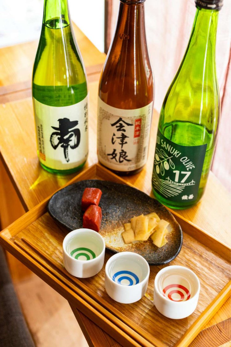 本日の飲み比べセットはおちょこ3種＋おつまみ2種（この日は自家製の大根辛子漬けと赤こんにゃく）付き1000円。