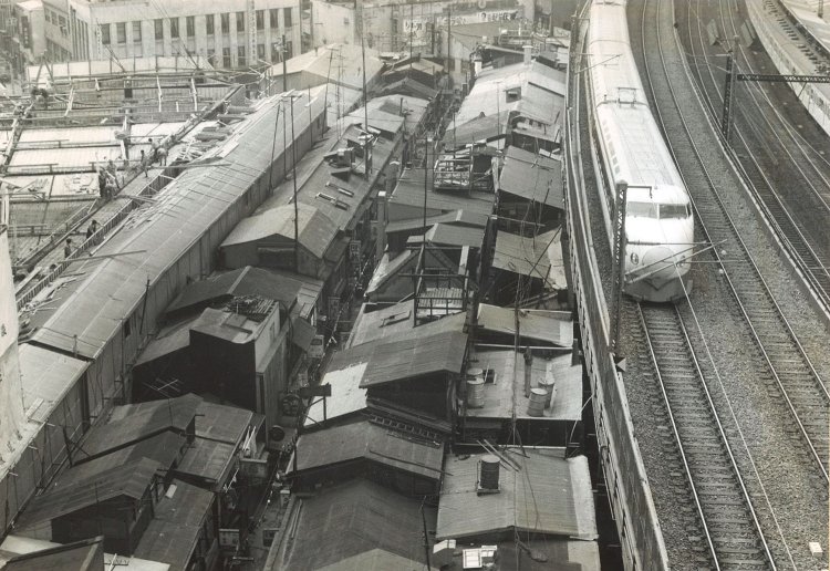 1965年頃の撮影。写っているバラック街の屋根が「すしや横丁」。右側には新幹線が走っている（写真提供＝東京交通会館）。