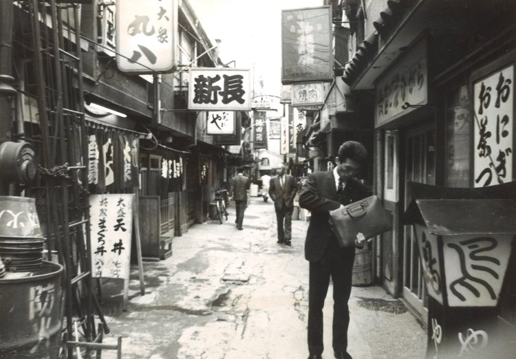 1965～1967年頃のすしや横丁。駅前から銀座方面に向けてなだらかな丘のようになった土地に、背中合わせに2軒ずつの木造2階建てが国鉄の線路に沿うように、まさにすし詰めで1列続き、路地をはさんで今度は1軒ずつの店が並んだ列が2つ、合計で3列あった。写真の当時、店は100軒超あり、中には3階を建て増しした店もあった（写真提供＝東京交通会館）。