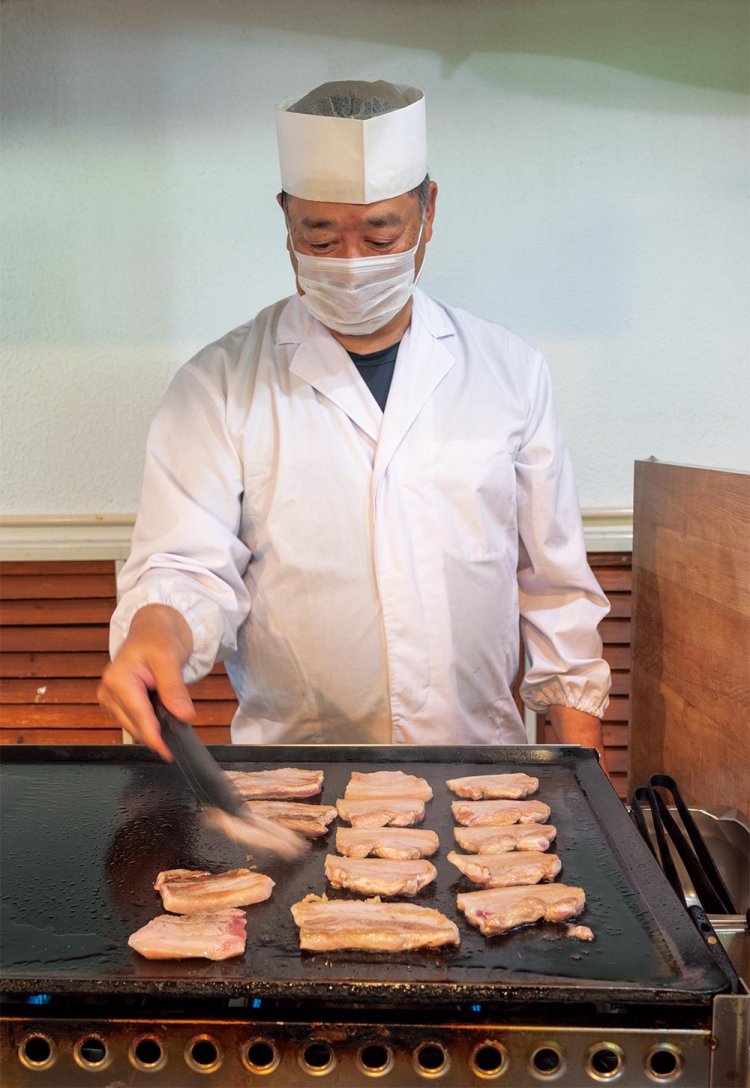 ライブキッチンでは料理長が豚肉を焼く。