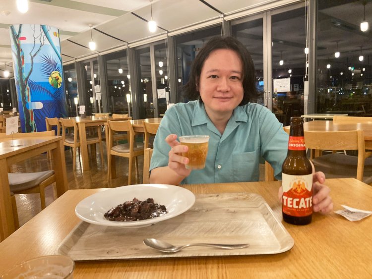 テカテを飲みながらフェジョアーダを食べるbutajiさん。