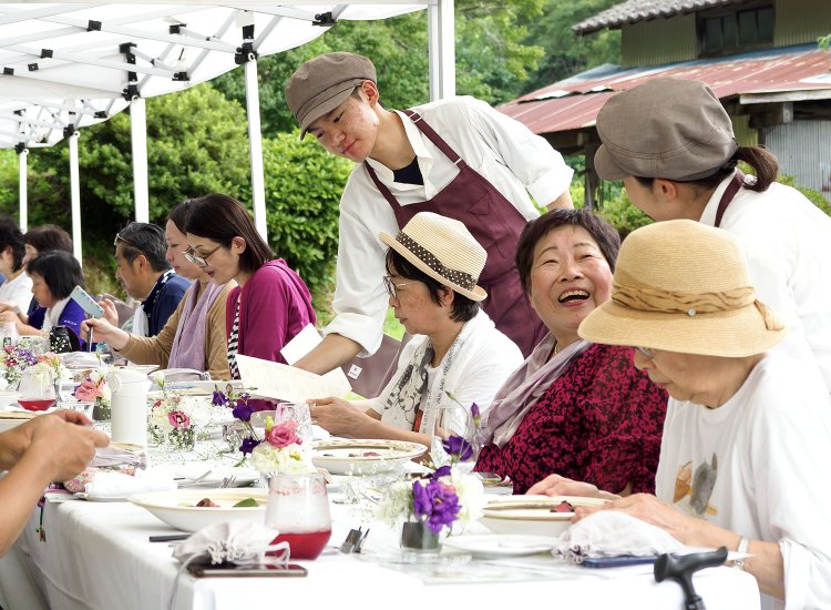 福島県飯舘村で開催されたFood Camp（R）。参加者と同じテーブルに生産者も着席して楽しむ（撮影＝桂嶋啓子）。