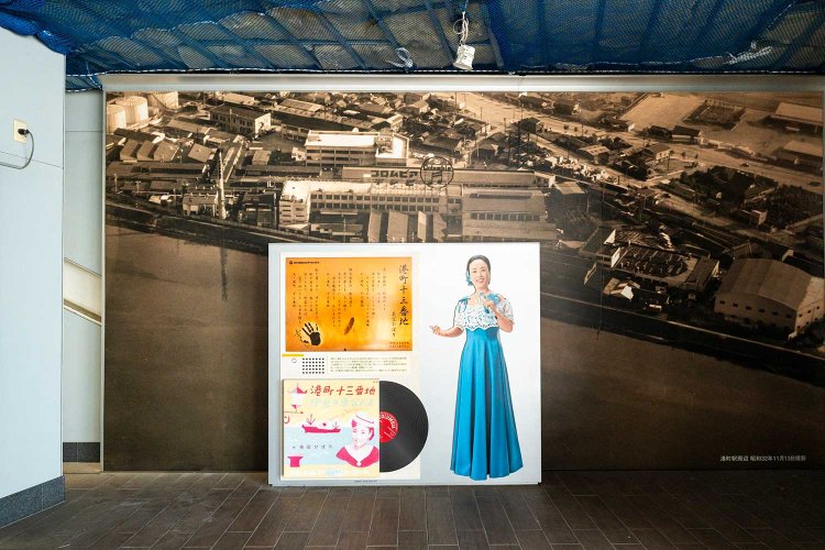 歴史写真とともに立つ美空ひばりの歌碑。ボタンを押すと歌声が響く。