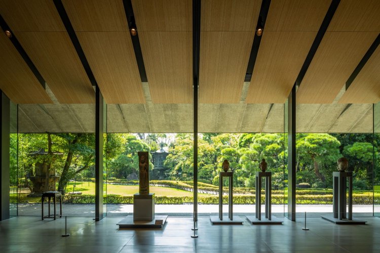 庭園に面したホールには仏頭などを展示。天井材はシンボルツリーの竹。