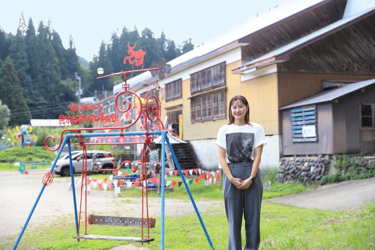 「まつだい駅前の『越後まつだい里山食堂』では、12月1日まで新米フェアも！」と越後妻有（えちごつまり）里山協働機構の大津歩未さん。背後は『鉢&田島征三 絵本と木の実の美術館』。