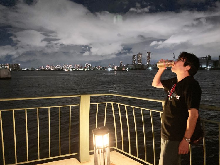 夜の川面を眺めながら佇むパリッコさん。