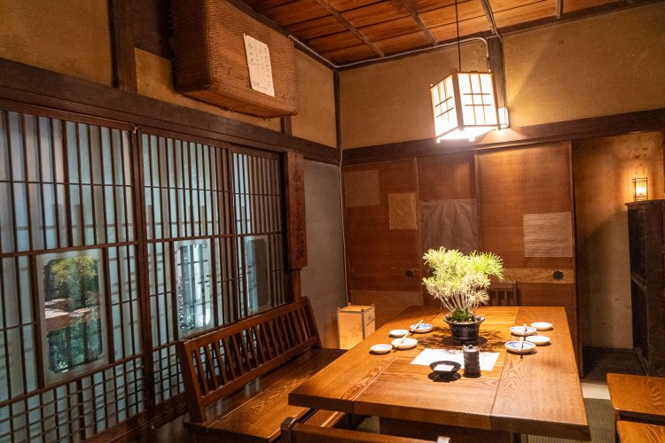 2階テーブル席。残っていた茶道の教授看板や行李（こうり）も活用している。