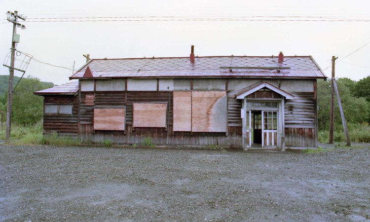 現役末期の沼牛駅舎。廃駅のように見えてしまうのは、廃止直前で駅名標が回収され、事務室側は板で塞がれていたからだろう。1995年8月撮影。