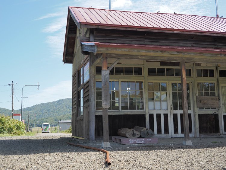 沼牛駅舎を手前にして去っていくJRバス深名線。
