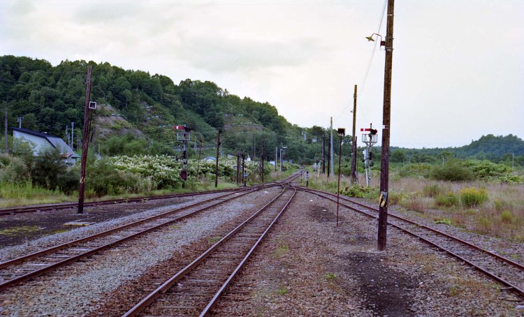 朱鞠内駅の構内を上りホームから見る。深名線は廃止まで腕木式信号機であった。全盛期は右手に転車台と機関車の滞泊設備があった（1995年8月撮影）。