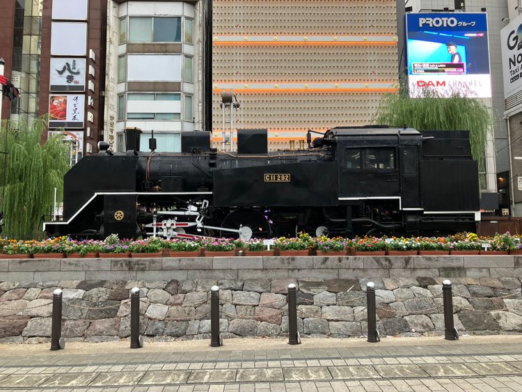 新橋を象徴するSL。先頭部にあった女性像「愛の像」は、高輪築堤の設置工事に伴い、近くの桜田公園に移設された。