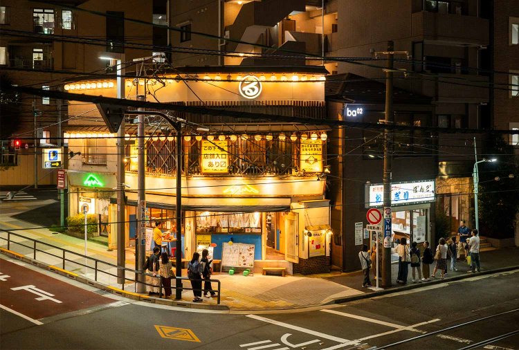駅北口でネオンがきらめく「東京大塚のれん街」。『おにぎりぼんご』の行列は夜まで続く。