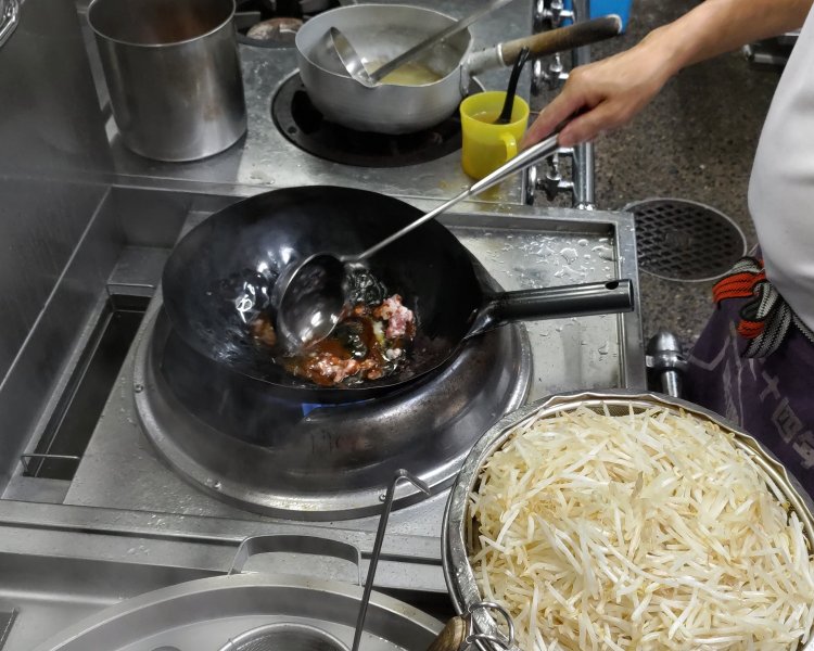 まずは中華鍋で、特製の味噌と挽き肉を加熱していく。味噌のいい香りが、湯気と共に立ちのぼる。