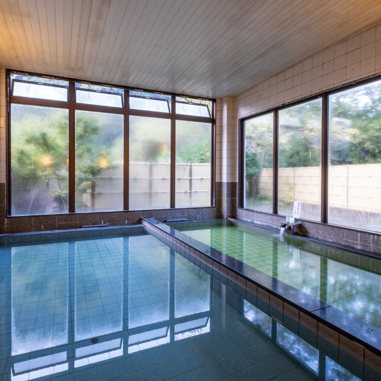 源泉浴槽と加温源泉浴槽が整然と並ぶ内風呂。加水なしのかけ流しで、源泉は飲用もOKだ。