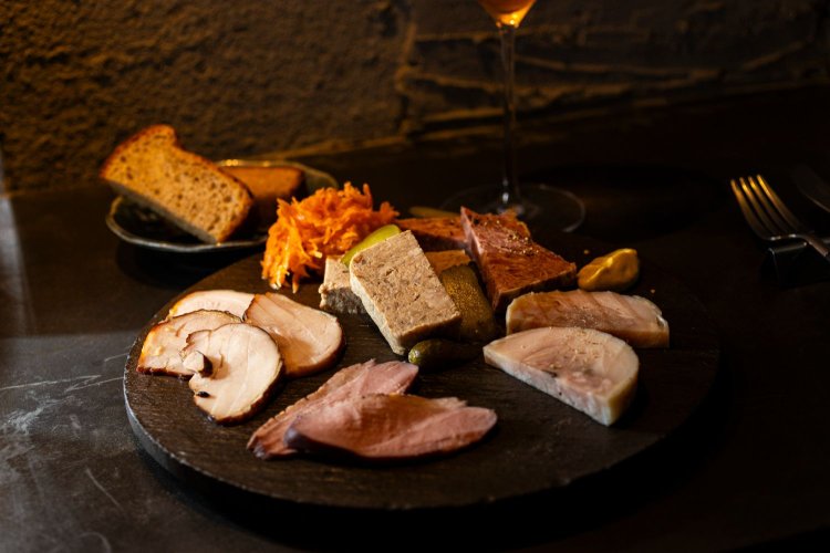 パテや豚肉のリエット、燻製した鶏モモ肉など、シェフ特製のシャルキュトリーの盛り合わせ（5種）1880円。自家製パンも添えて。