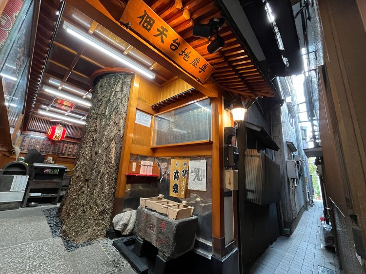 人ひとりが通れる路地の奥にある佃天台地蔵尊。イチョウの幹の左奥の石板に地蔵尊が刻まれている。