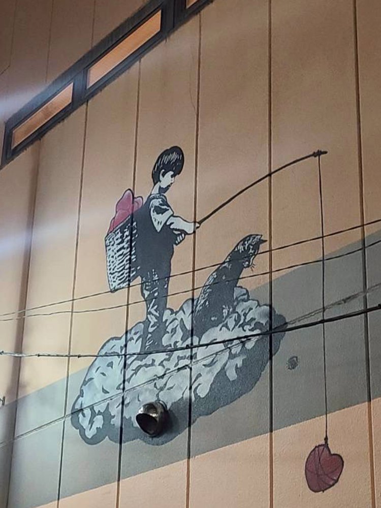 少年と猫がハートを釣り上げている壁画は、「不二屋書店」の頃から変わらずあるもの（友人Mさん撮影）。