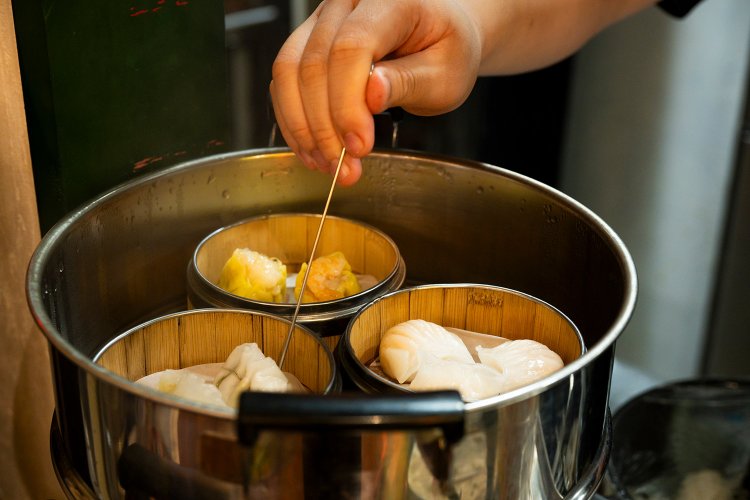 点心の蒸し上がりを確かめる。