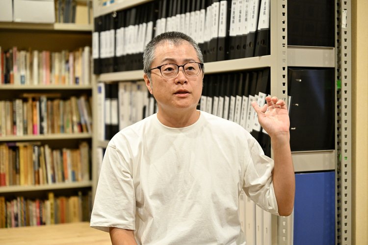 渡辺さんの背後には、全国各地で集めてきた膨大な量の遊郭に関する資料が並ぶ。