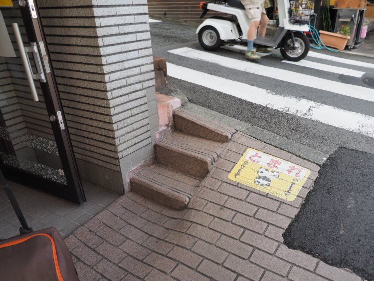 道路から建物入り口までの勾配を調整し、階段とスロープを同居させている。
