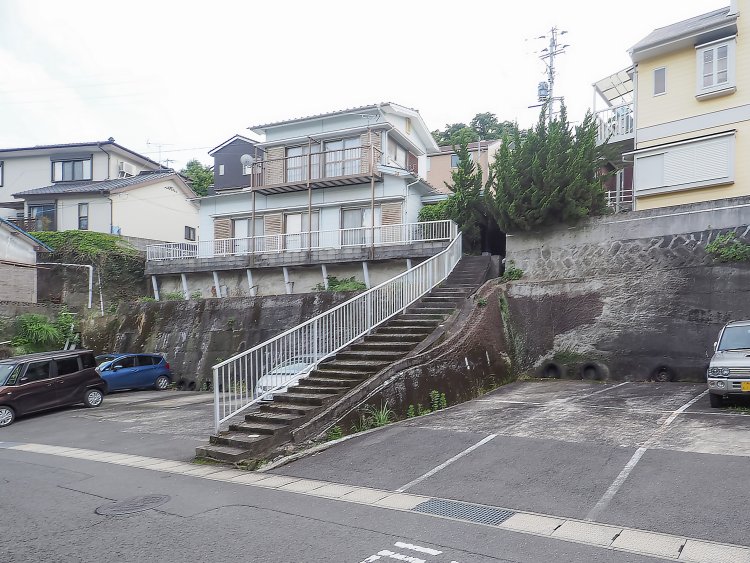 傾斜地の住宅が駐車場に。残された階段だけに、かつての地形が残されている。