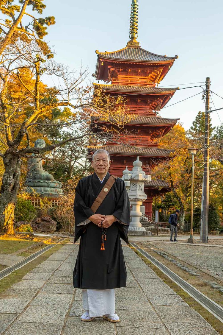 執事を務める田中見定（けんじょう）さん。朱色が美しい五重塔は国指定重要文化財だ。