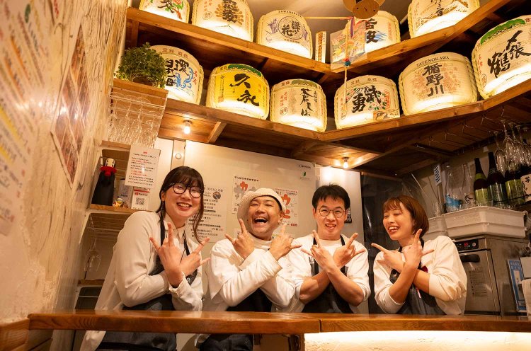 渡部さん（左から2番目）、シェフのコミカドさん（右から2番目）と明るいスタッフ陣。「酒選びに悩んだらおすすめを聞いて！」。