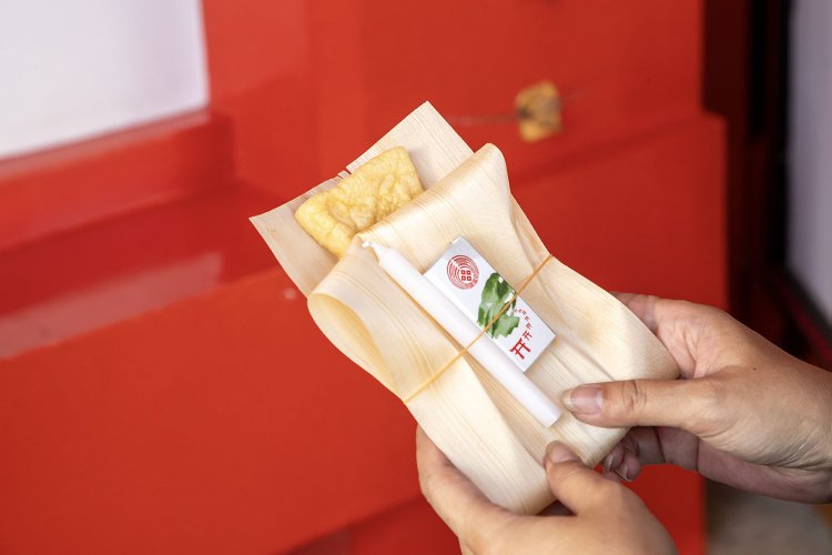 お供え物は狐が好物とする油揚げ。境内駐車場の手水舎前と売店で150円で購入できる。