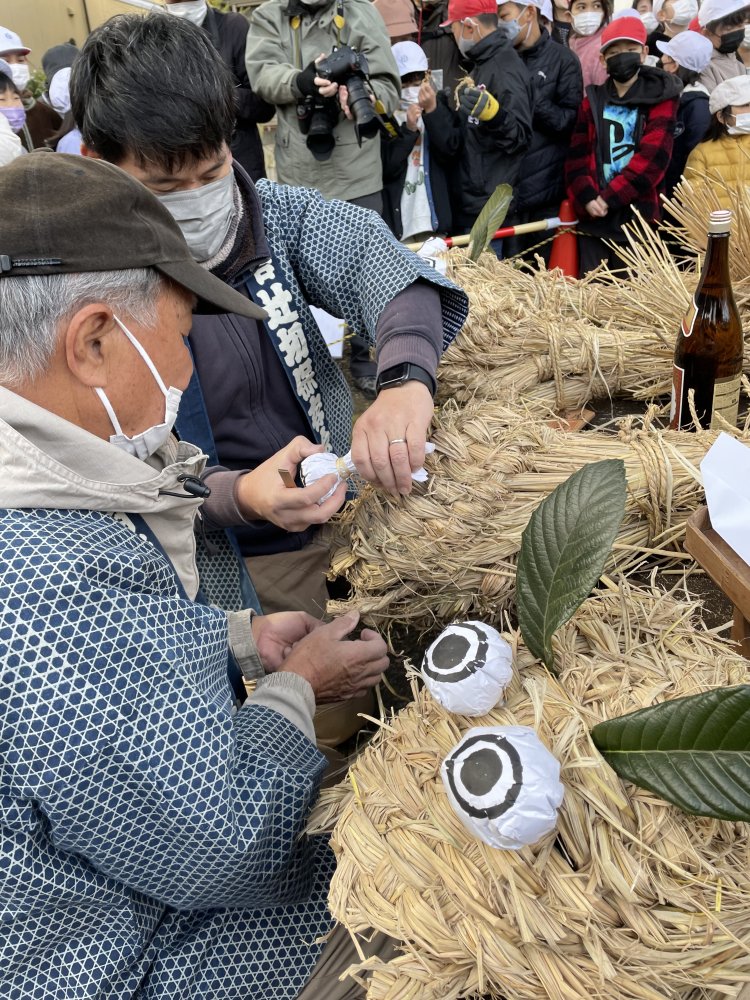 ワラ灰を半紙でくるんだ目玉を一体ずつ大蛇につけていく。