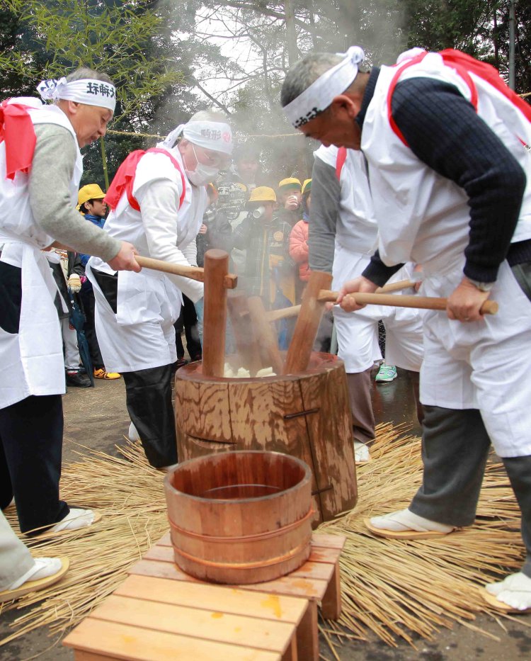 しめ縄の中で、4人が息を合わせて餅をつく。この後「餅ぶつけ」が行われる。