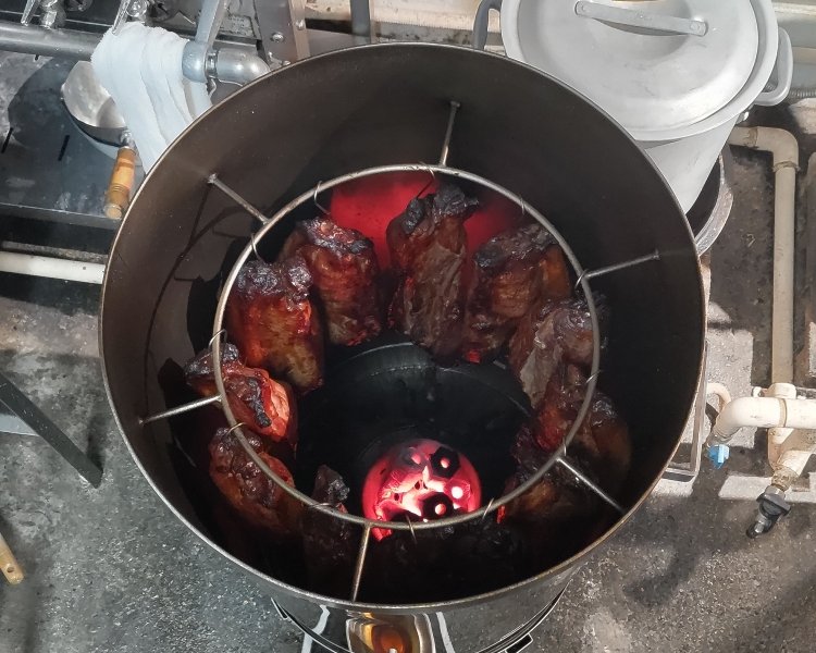 焼豚は厨房の吊るし釜で約90分かけて仕込む。炭火による遠赤外線で旨味が凝縮される。