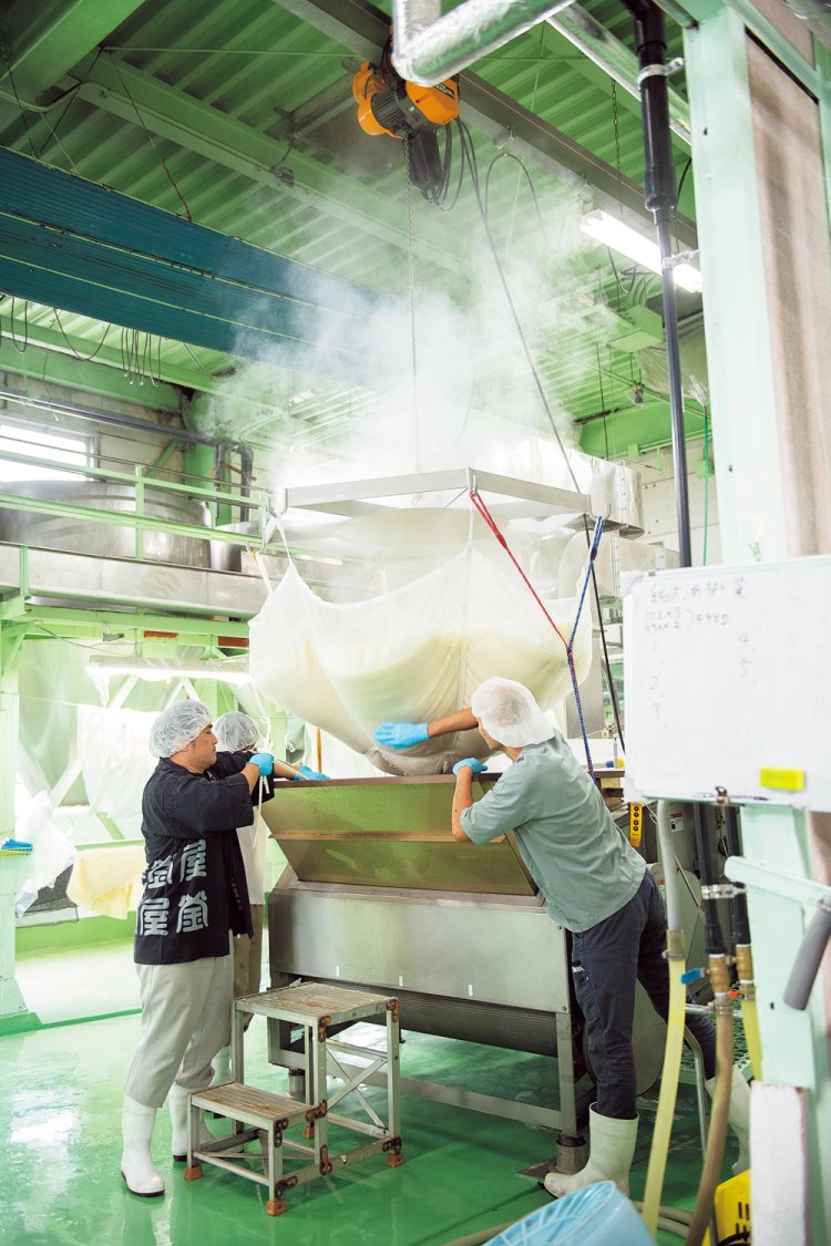 蒸しあがったばかりの米を引き上げたところ。米の甘い香りが工場全体を包み込む。