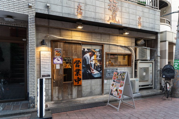 高円寺あづま通り商店街に面し、入り口のそばに背脂中華そばの歴史が書かれている。