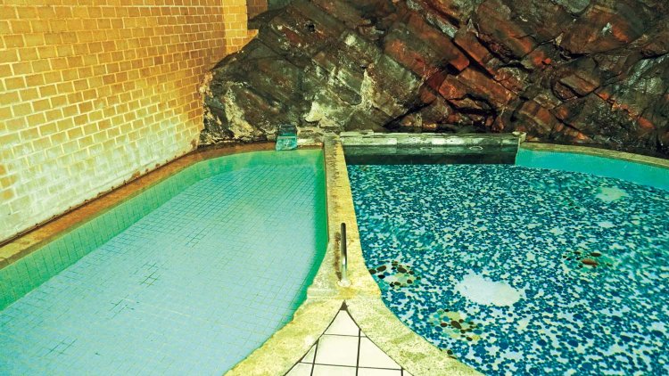 1300年の歴史を誇る下部温泉。大岩の下から湧く源泉が浴槽に注がれる。右がぬる湯の源泉風呂。