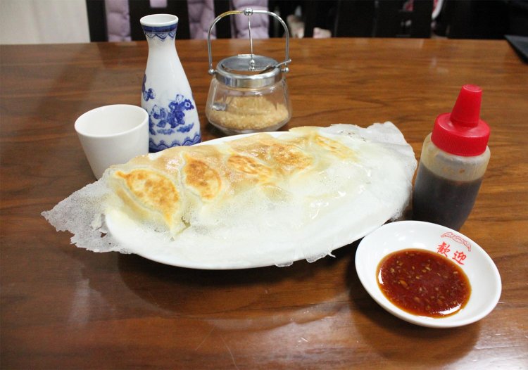 羽根付き焼き餃子（1人前5個）385円と紹興酒（一合）605円。餃子は特性ダレでぜひ。