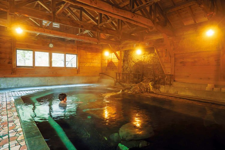 鳥居（写真奥）から流れ出すちょいあつ湯と、岩間からぷくぷく湧くぬる湯。150年前から変わらぬ姿を留める名物の大岩風呂。