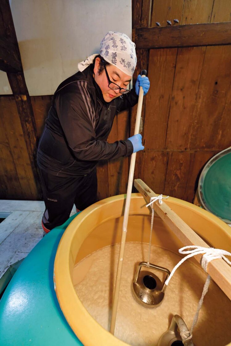 もろみに櫂（かい）を入れ、よく攪拌（かくはん）して発酵を促す。