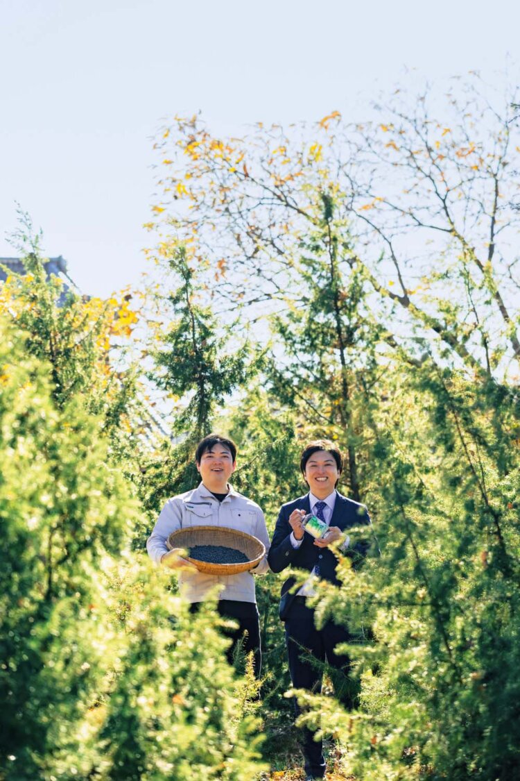 育成中のジュニパーベリーの木に囲まれて。代表の松崎裕大さん（右）と弟で蒸留長の翔大さん。