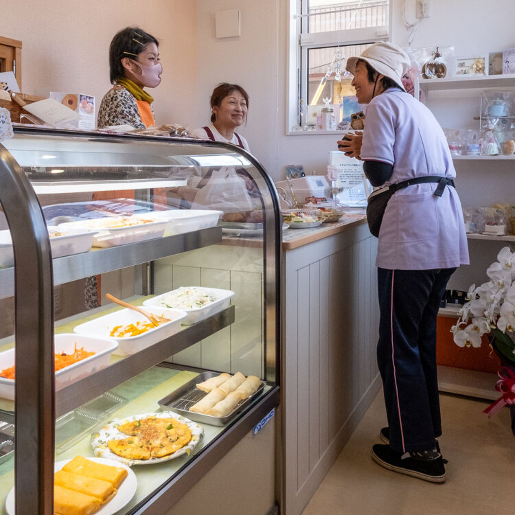 「さて、今日のお弁当の総菜は何にしようかしら」と店頭での地元常連客とのやりとりも微笑ましい。
