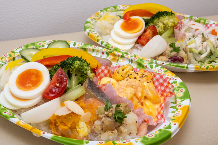 ごはんが見えなくなるほど総菜や副菜、サラダを詰めた日替わり弁当