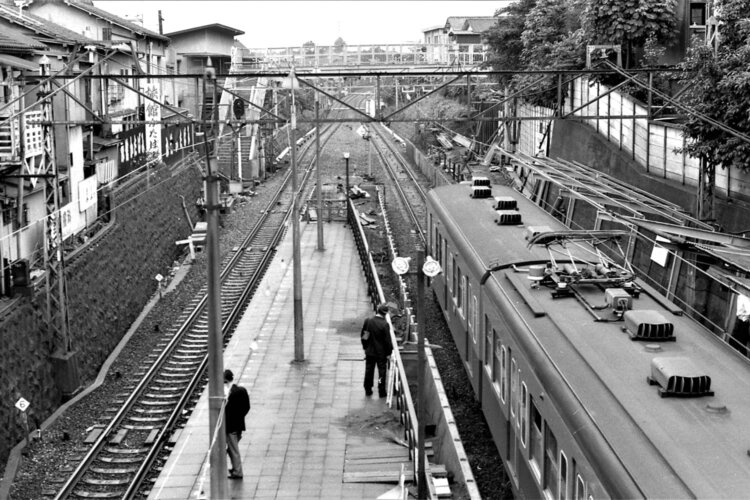 電車鑑賞スポットにもなった1番目の踏切があった跨線橋から、世田谷代田駅方面を望む。10両化のためのホーム延伸工事が開始され、2番目の踏切が跨線橋となっている。小田急の通勤電車は青と黄色のツートンカラーであった（1969年6月撮影）。